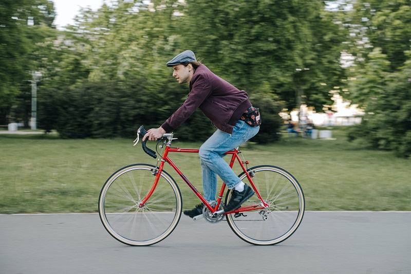 Best States for Bike Riding a Man Riding a Bike Along a Paved Path