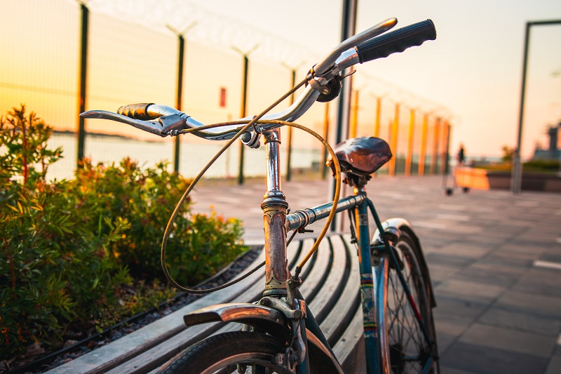 Top 5 States for Biking Trails Close Up of a Bike Leaning Against a Rail Next to a Body of Water During Sunset