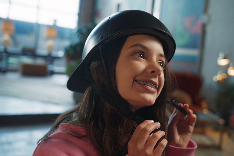 Why ProLids Helmets were Invented Young Girl Holding the Chin Straps of a ProLids Helmet