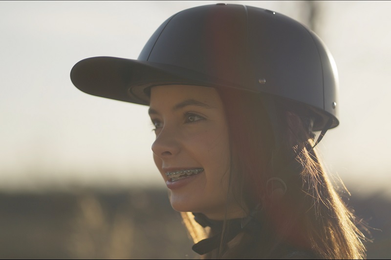 How to Get Kids Excited to Wear Helmets a Girl Outside Wearing a ProLids Helmet Smiling