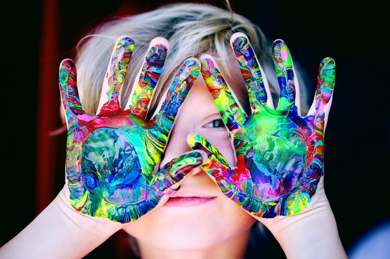 How to Personalize your ProLids Helmet Close Up of a Child with His Hands Held Up and Covered in Different Colored Paint