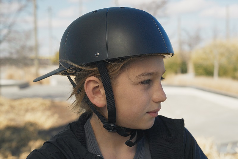 Helmet Strap Features a Profile View of a Young Girl Wearing a ProLids Helmet