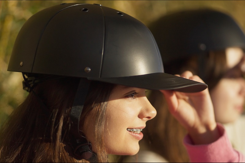 How to Know When to Replace Your Bike Helmet a Girl Wearing a ProLids helmet Sitting on a Park Bench