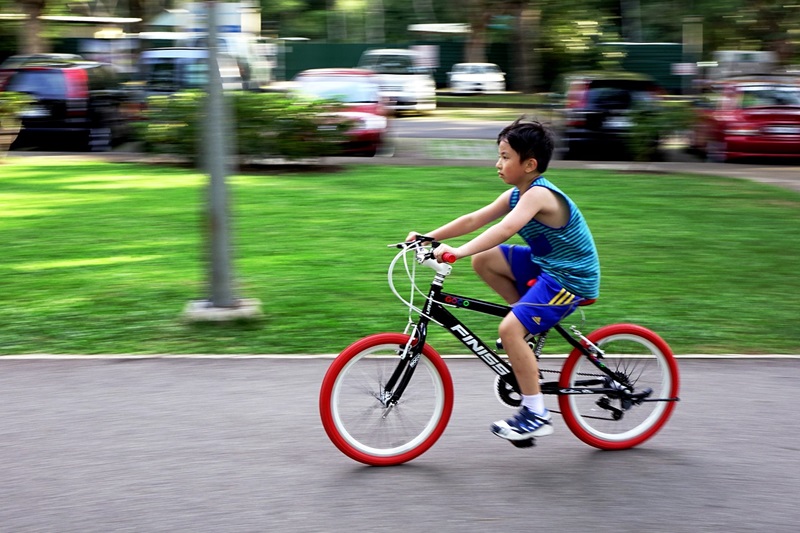 How to Size a Bike for Your Child a Little Boy Riding a Bike Outside