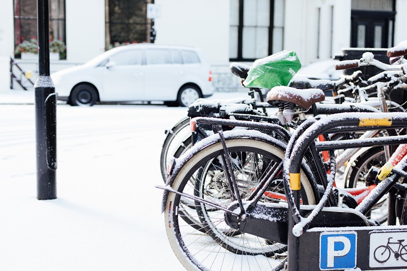 Bike Safety Tips for Cooler Weather a Row of Bikes in a Bike Rack with Snow on the Ground