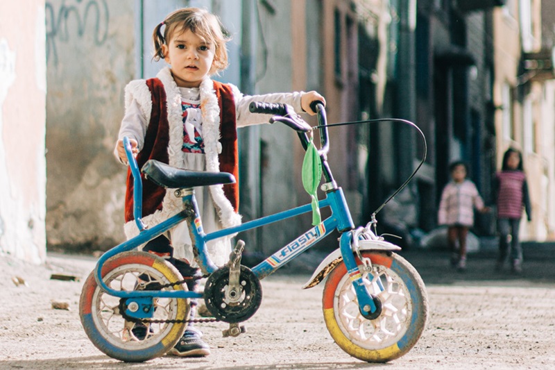 Tips to Transition from Training Wheels a Young Girl Standing Next to a Small Bike without Training Wheels