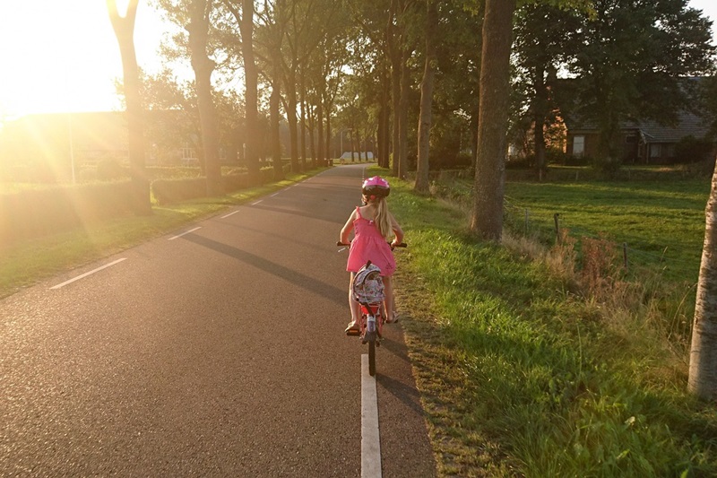 Riding a Bike to School Advantages and Disadvantages for Kids a Young Gril Riding a Bike Down a Trail Lined with Trees