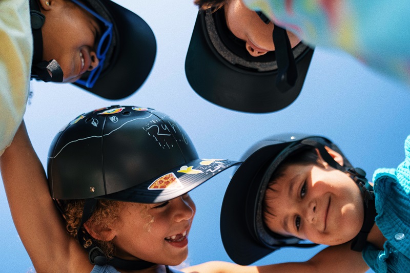 Why ProLids Interchangeable Brims are Perfect for Kids Four Kids Standing in a Circle, Each Wearing a ProLids Helmet Looking Down at the Camera