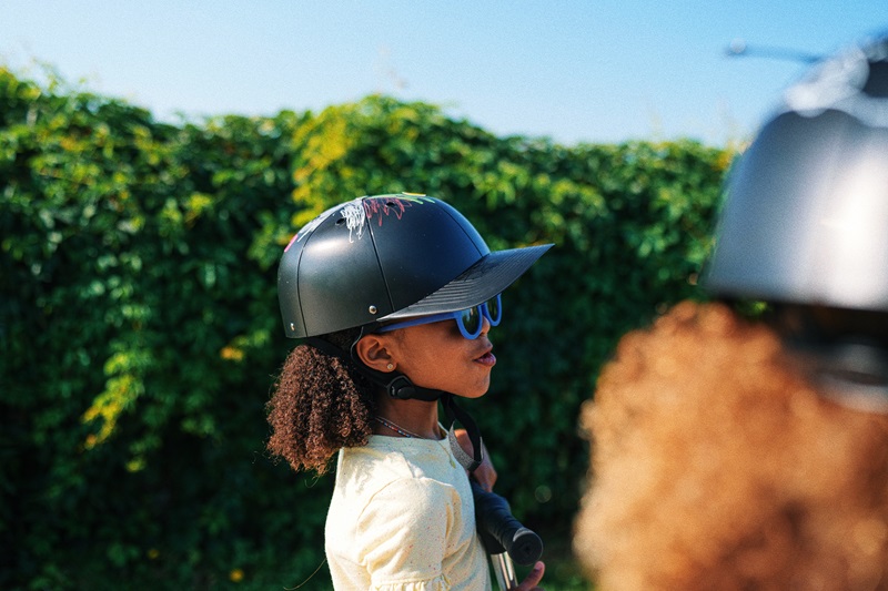 Why ProLids Interchangeable Brims are Perfect for Kids a Young Girl Wearing a ProLids Helmet While Riding a Scooter with Friends