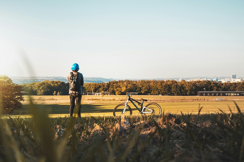 Best Bike Trails in Minnesota a Person Standing Next to a Bike on a Trail Overlooking a Field of Golden Grass