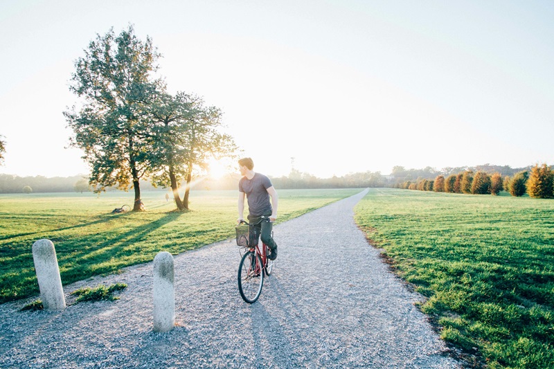 Best Bike Trails in Minnesota a Man Riding a Bike on a Gravel Trail Lined with Grass