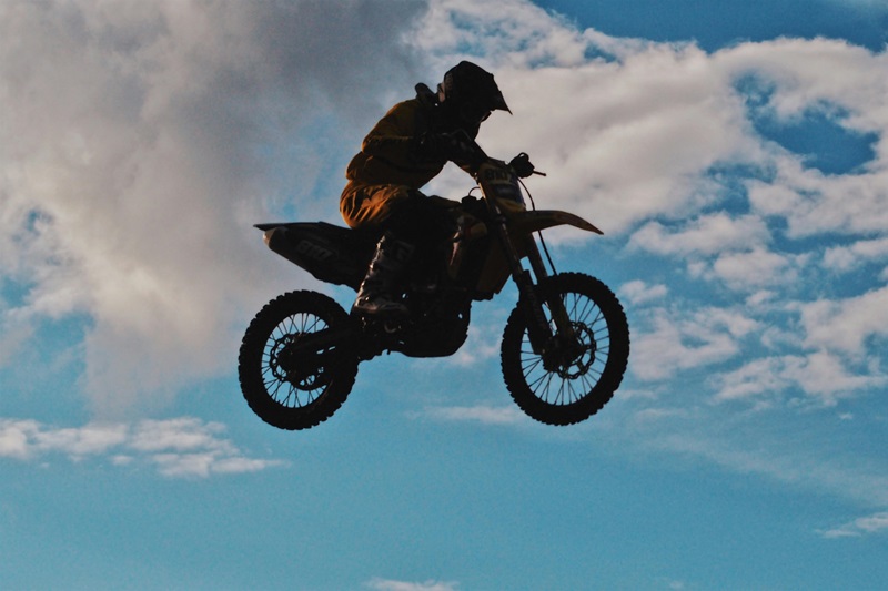 Types of Helmets for Kids a Person on a Dirt Bike in the Air Wearing a Dual-Sport Helmet