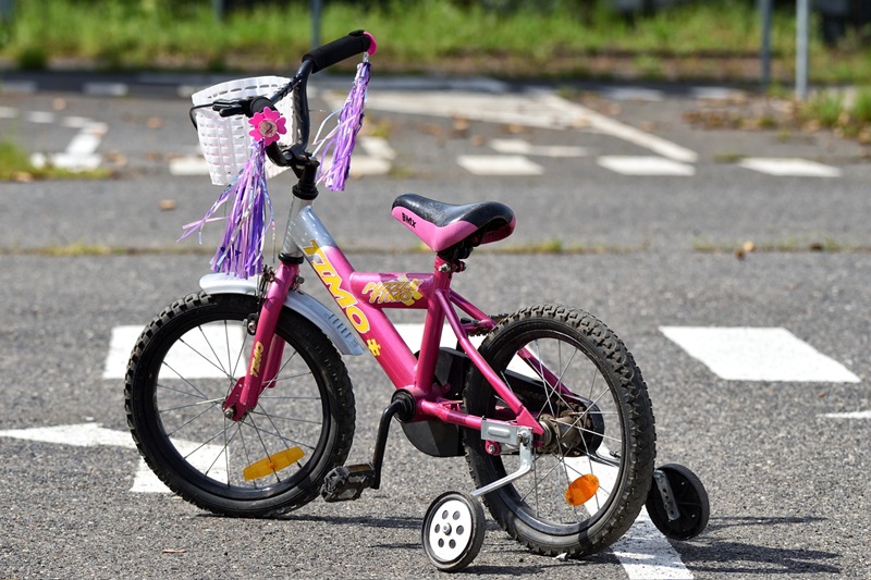 Best Bike Trails for Kids in Austin Close Up of a Pink Bike with Training Wheels in a Parking Lot